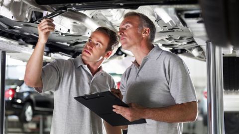 Technicians under a car